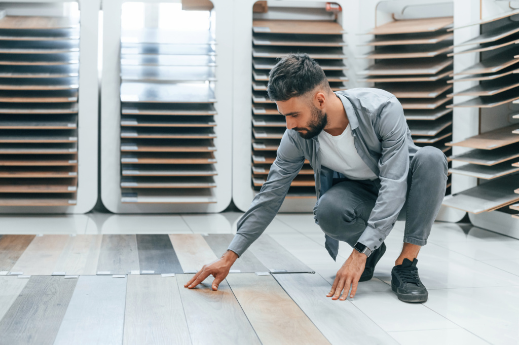 Man browsing flooring samples in a home goods store